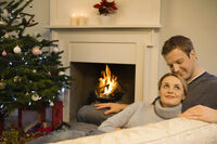 picture shows a couple sitting together in front of an open fire
