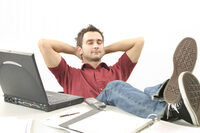 Photo shows a man relaxing by his computer