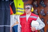 photo shows a person wearing personal protective equipment, including hearing protection
