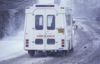 Photo shows an ambulance driving in the winter weather