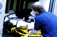 Photo shows a patient being loaded onto an ambulance