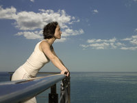 Photo shows a woman leaning on a balustrade